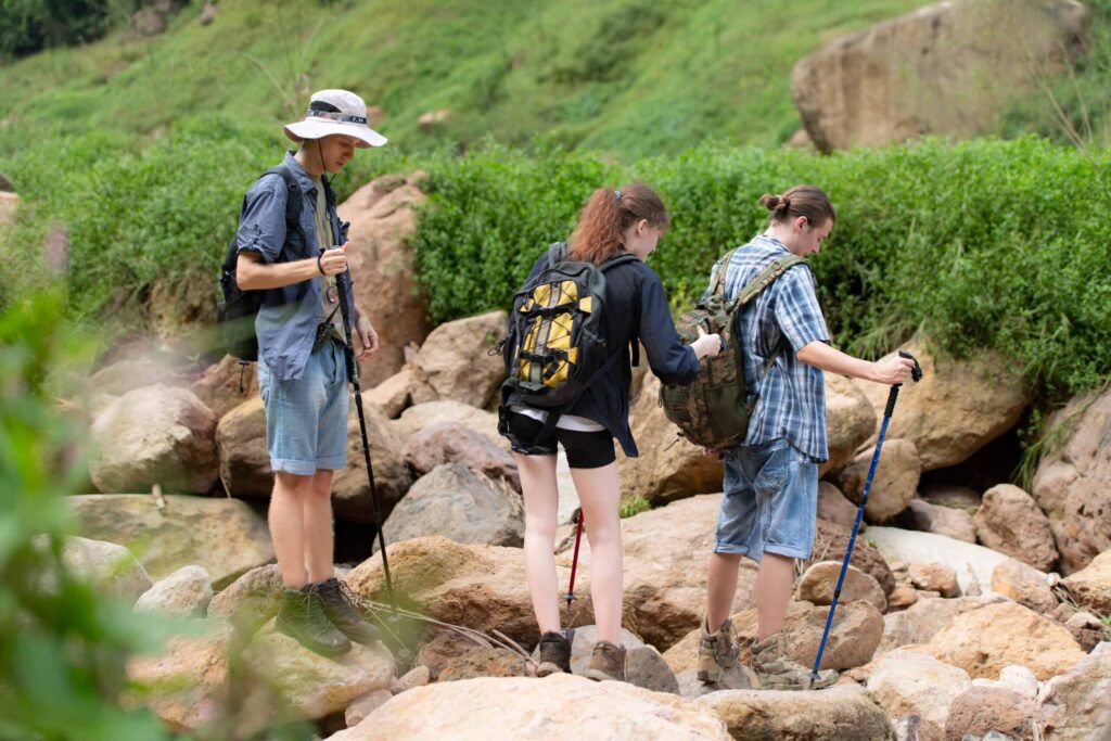 Group of tourists with backpacks walking on the trail in the river and mountains. Is Germany Safe? Insider Travel Security Tips