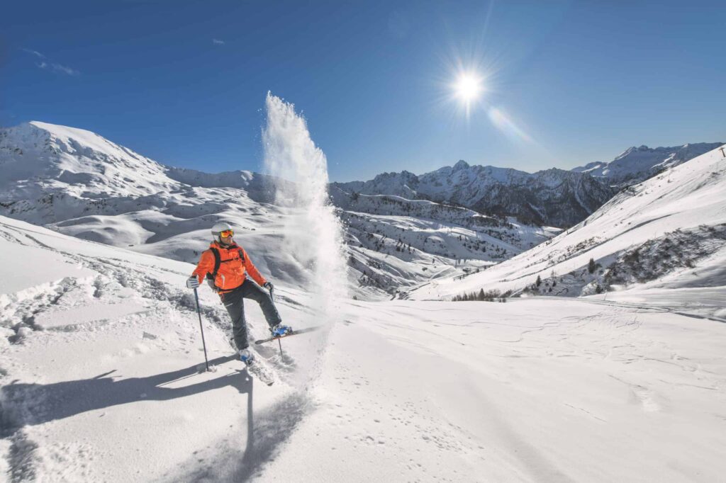 Off-piste skier lifts snow with skis after a ski. Does It Snow in Australia?